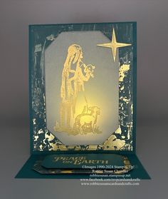 a christmas card with an image of the nativity scene in gold on green paper