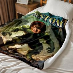 a bed covered in a blanket with an image of a boy on the front and back