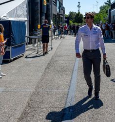 a man walking down the street carrying a bag