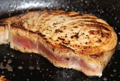 a piece of meat cooking in a frying pan with oil on the top and bottom