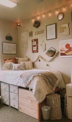 a bedroom with white furniture and lots of pictures on the wall above the bed is decorated with string lights