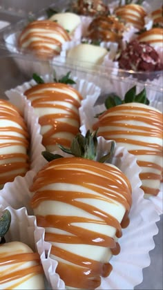 chocolate covered strawberries with white and brown glaze on them are lined up in plastic trays