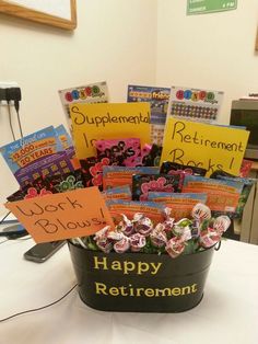 a bucket filled with lots of candy and congratulations signs on top of a white table