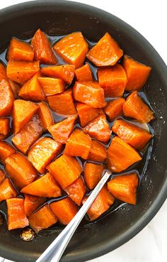 cooked carrots in oil being stirred with a spatula on top of the skillet