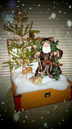 a santa clause sitting on top of a wooden box with christmas decorations and trees in it