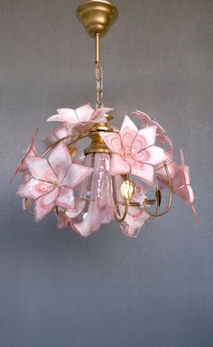 a chandelier with pink flowers hanging from it's center and two lights on each side