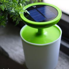 a solar powered device sitting on top of a potted plant