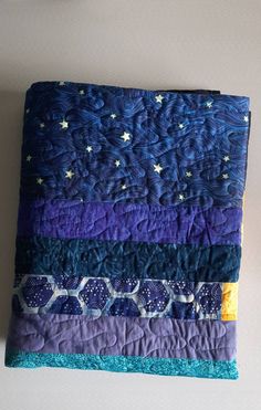 a purple and blue quilt with stars on it