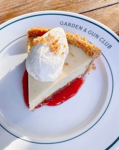 a piece of pie on a plate with ice cream and strawberry sauce in the middle