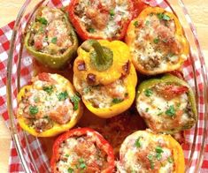 several stuffed peppers in a glass dish on a red and white checkered cloth