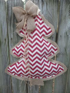 a red and white christmas tree ornament hanging on a fence with burlocks