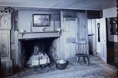 an old photo of a living room with a fire place and chair next to the fireplace