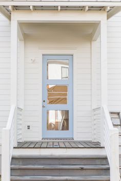 a white house with a blue door and steps