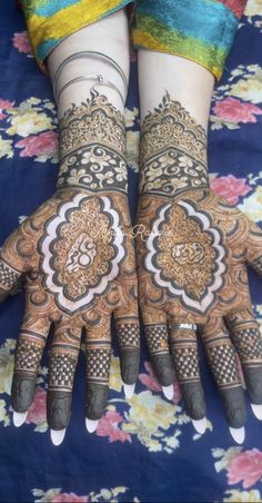 two hands with henna designs on them