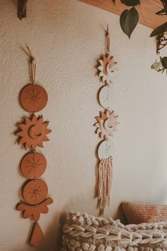 three sun and moon wall hangings on the wall above a bed with a pillow