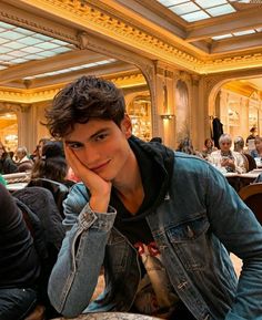 a young man sitting at a table in a restaurant