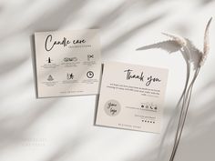 two cards with the words thank you on them are next to a flower and a white background