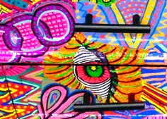 the colorful artwork on the side of a building has an eye in it's center