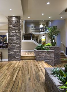 a living room filled with lots of furniture next to a stair case and planter