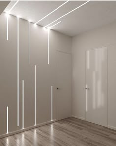 an empty room with white walls and lights on the ceiling is lit by recessed lighting