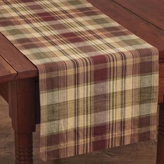 a plaid table runner on top of a wooden table