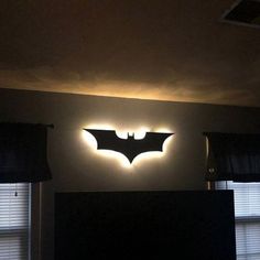 the batman logo is lit up on the wall