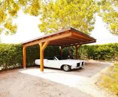 a white car parked under a wooden shelter