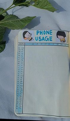 an open cell phone usage book next to a plant