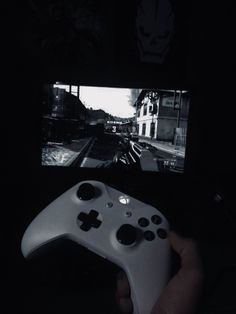 a person holding a video game controller in front of a tv