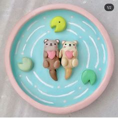 two bears are sitting in the water on a blue plate with green and yellow decorations