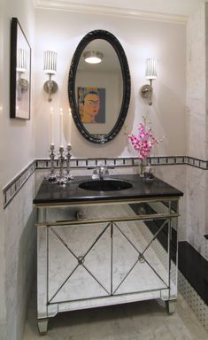 a black and white bathroom with a mirror, sink and toilet paper roll on the wall