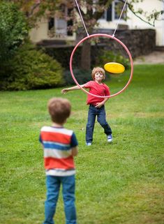 two young boys playing with a hoop and frisbee