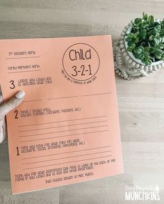 a child's birth record being held up by a person with their hand on top of it