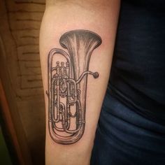 a black and white tattoo of a french horn