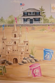 a child's room with a sand castle painted on the wall