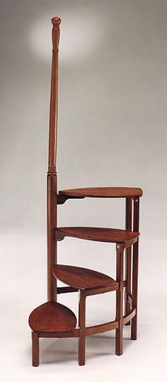 a wooden chair with a curved back and foot rest in the shape of a ladder