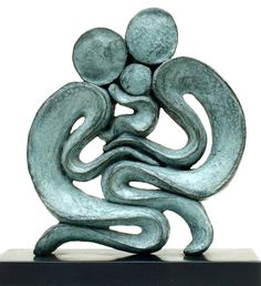 a sculpture of two people hugging each other on top of a black base with a white background