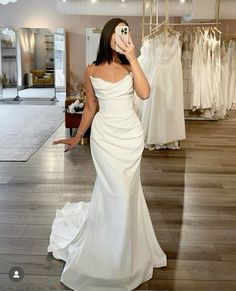 a woman taking a selfie in a wedding dress shop