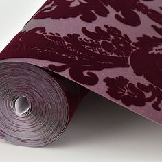 a roll of red and purple wallpaper on a white surface