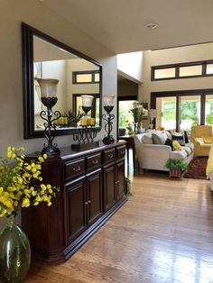 a living room filled with furniture and a large mirror