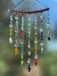 a wind chime hanging from a window with lots of colorful glass beads on it