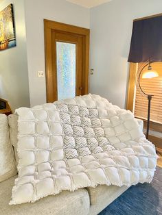 a couch covered with a white blanket in a living room