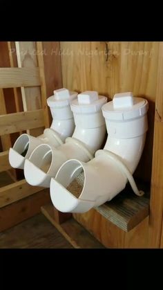 four white rain boots hanging from the side of a wooden wall