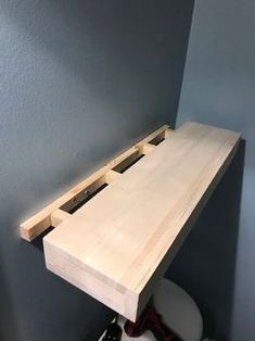 a wooden table sitting on top of a white toilet