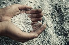 a person holding sand in their hands