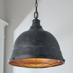 an old fashioned light hanging from a ceiling fixture in a room with white walls and windows