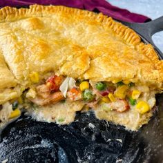 a chicken pot pie is shown in a cast iron skillet with a piece cut out