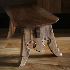 a wooden stool with two metal handles on it