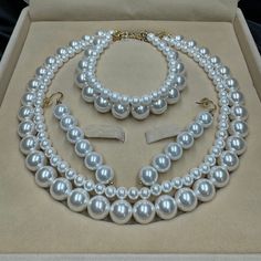 a white pearl necklace and bracelet in a box