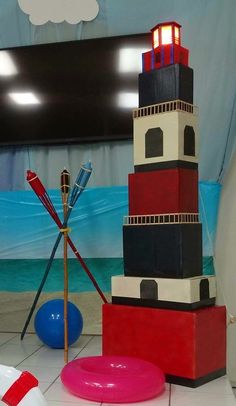 a lighthouse made out of legos sitting on top of a tile floor next to a blue ball